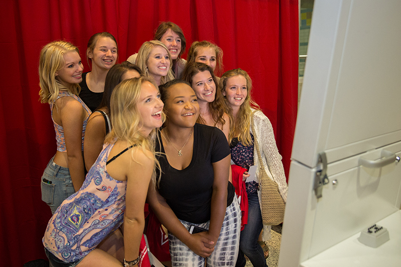 A group of female students pose in a photobooth